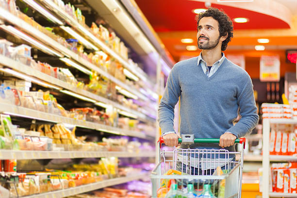 istock Young bearded man shopping at a grocery store 472290890