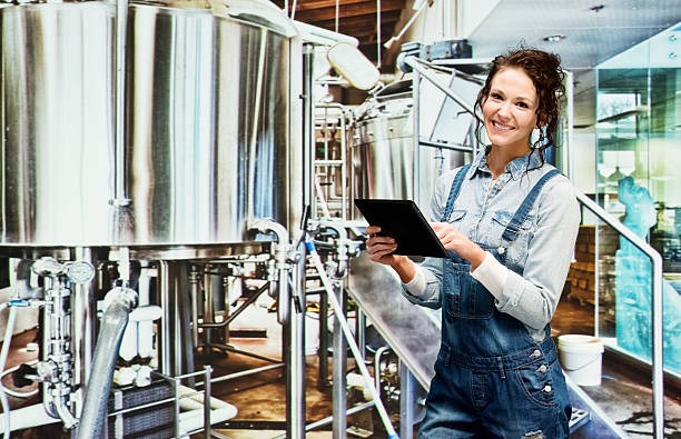 istock Smiling female brewmaster working in industry 472293766
