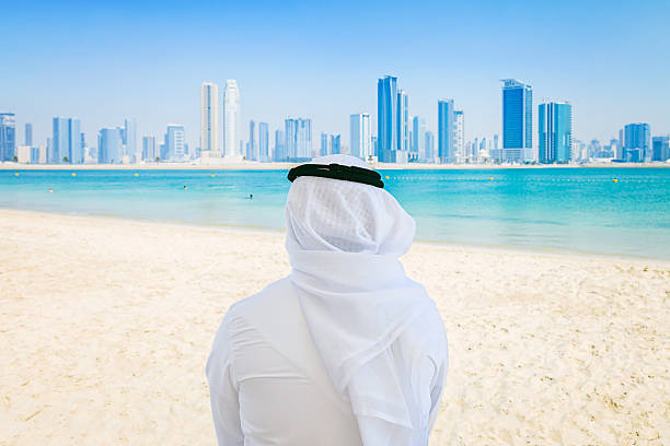 istock Businessman looking to city from beach 472294280