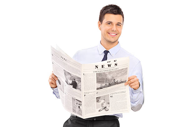 istock Handsome man holding a newspaper and leaning against a wall 472297438