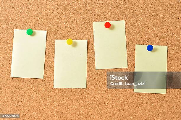 Close Up Of Yellow Note With Push Pins On Board Stock Photo - Download Image Now - PIN Entry, Bulletin Board, Adhesive Note