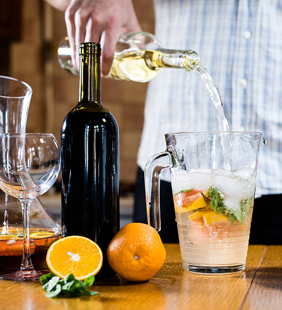 istock Man pouring white wine into a jar 472298570