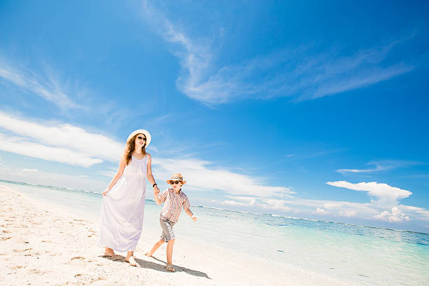 istock Happy beautiful young mother and son enjoying beach time with 472302138