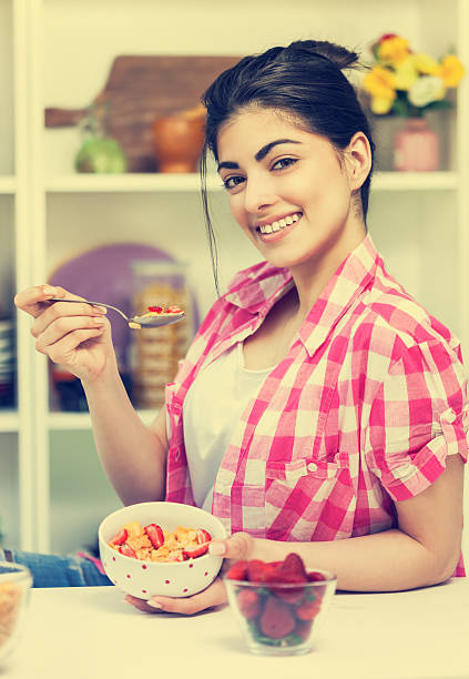 молодая красивая женщина, имеющие завтрак - eating cereal student human mouth стоковые фото и изображения