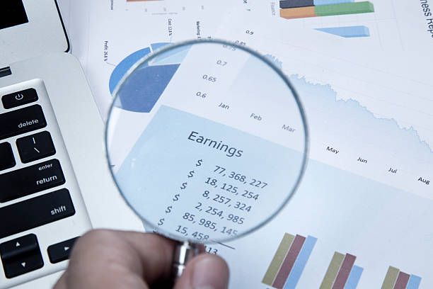 istock Businessman checking business reports with magnifying glass 472310702