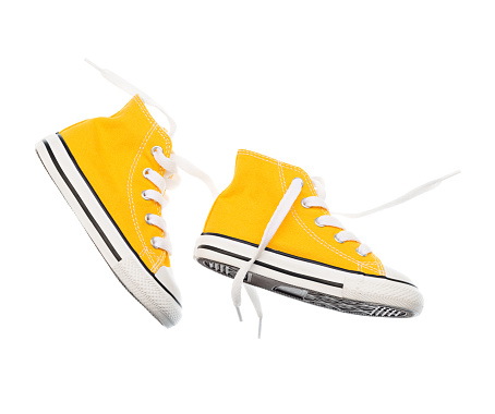 Yellow baby sneakers closeup isolated on white