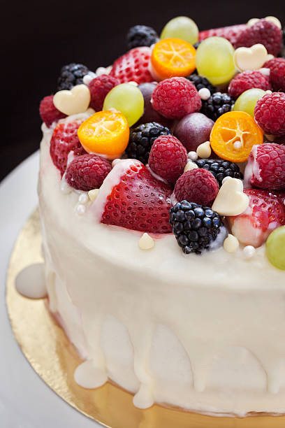 istock White chocolate cake decorated with fresh berries and fruits 472311978