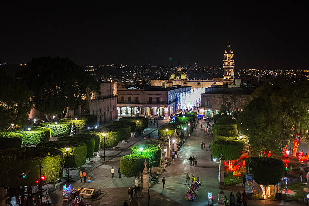 Night picture of the 'plaza de armas square' near the baroque style cathedral in the colonial city of Morelia in Mexico. St August church can be seen in the background.