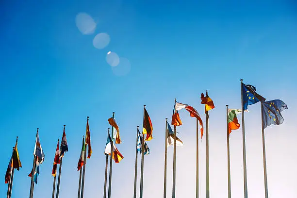 Photo of European Union flags against blue sky