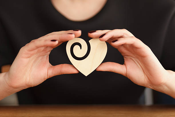 istock hands holding wooden heart 472318036