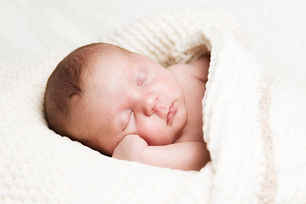 istock cute newborn baby sleeping in a soft blanket 472318574