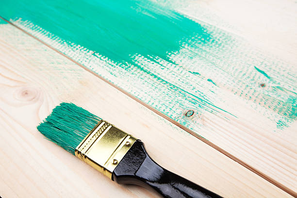 istock Varnishing a wooden shelf using paintbrush 472318700