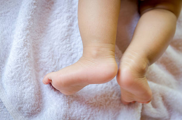 istock Close up baby feet on white fabric 472318724