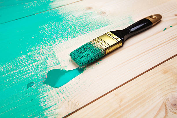 istock Varnishing a wooden shelf using paintbrush 472318756