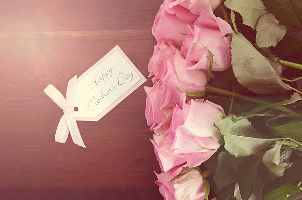 istock Mothers Day pink roses on rustic dark wood table. 472324674