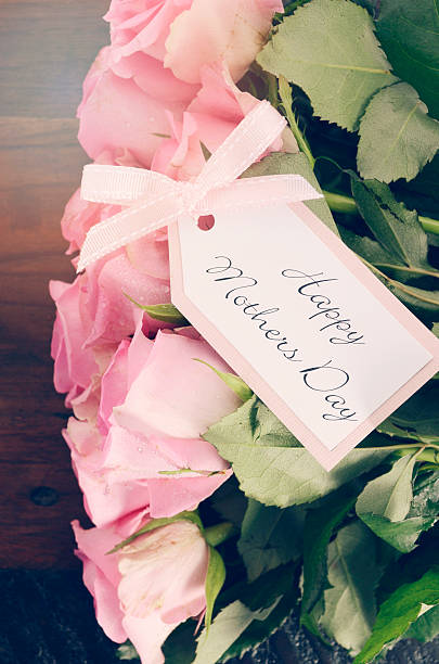 istock Mothers Day pink roses on rustic dark wood table. 472327744