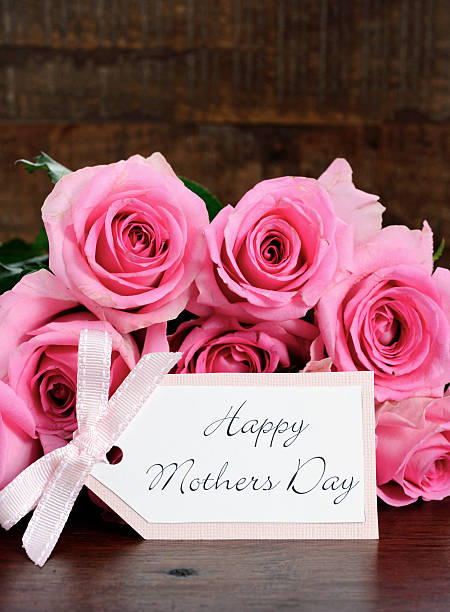 istock Mothers Day pink roses on rustic dark wood table. 472327758