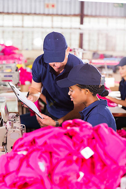 istock foreman and dressmaker looking at clipboard 472328164