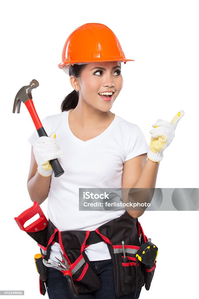 female construction worker in action A woman wearing a  tool belt full of a variety of useful tools and pointing up Hammer Stock Photo