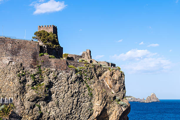 view of Norman castle in Aci Castello town and Cyclopean Rocks (Islands of the Cyclops), Sicily, Italy