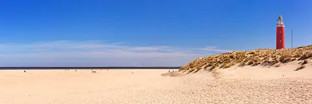 The lighthouse of the island of Texel in The Netherlands. Photographed from the beach below on a sunny day.