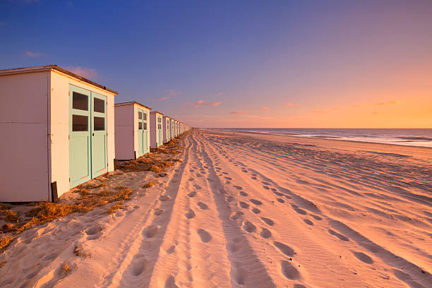 istock Row of beach huts at sunset, Texel island, The Netherlands 472335732
