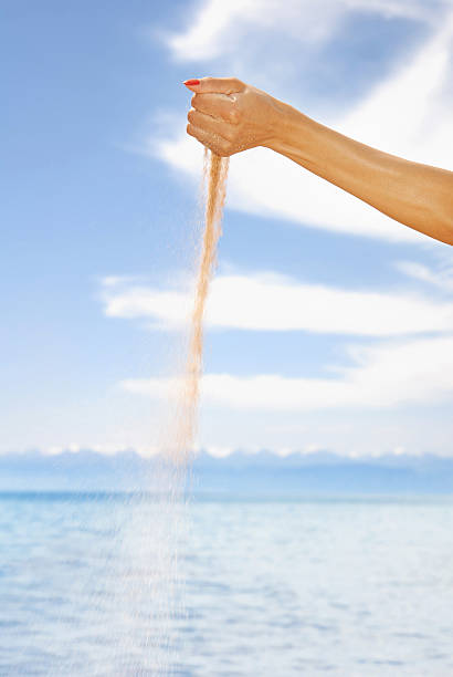 istock Woman hand playing with sand 472339548