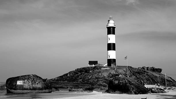 istock Lighthouse on the rocks on a beach 472342450