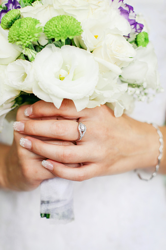 Color photo of a bride holding a wedding bouquet