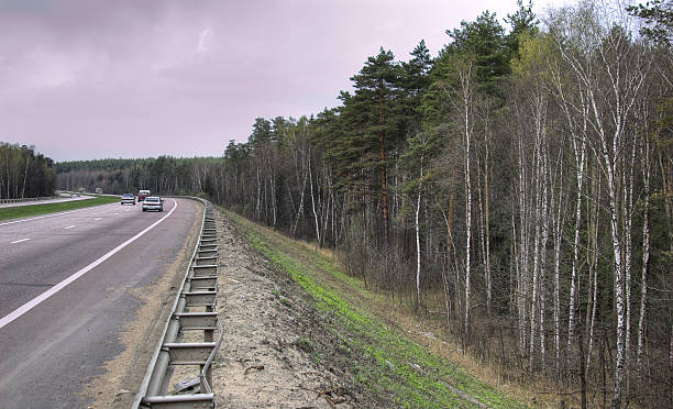istock High-speed highway with forest on roadsides 472349340