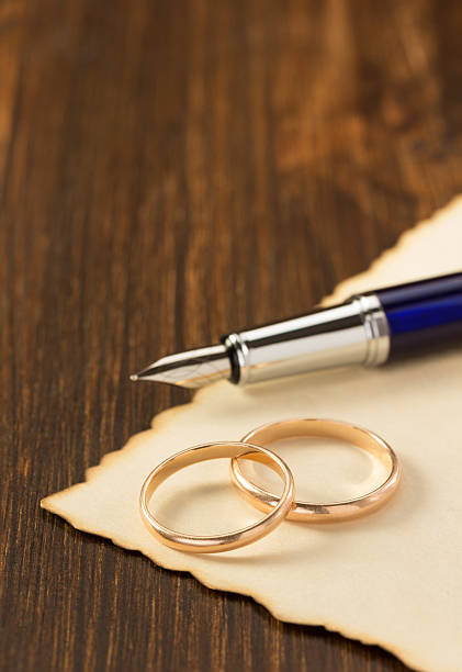 istock wedding ring and aged paper on wood 472350116