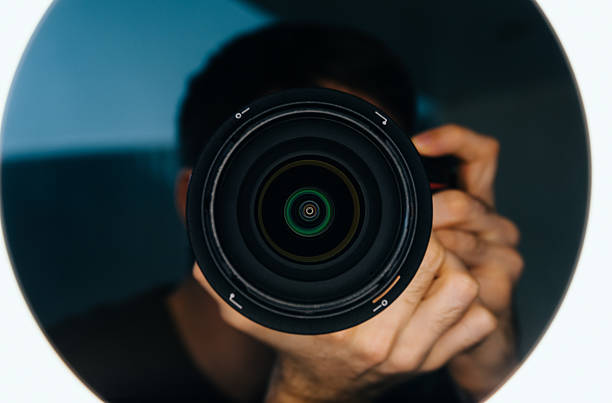 istock Photographer holds camera and lens 472350476