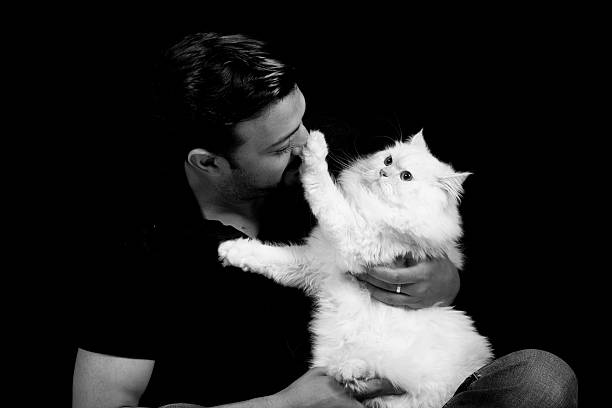 Man with a Persian cat directly looking into the camera. A monochrome creative composition.