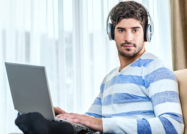 Shot of a young man listening to music through his laptophttp://195.154.178.81/DATA/i_collage/pi/shoots/783517.jpg