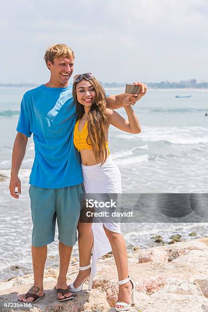 Young Happy Couple Taking Selfie Self Portraits At The Beach Stock Photo - Download Image Now