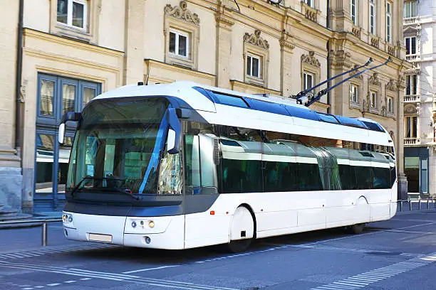 White trolleybus on a street of Lyon, France.