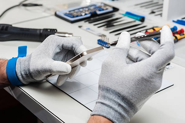 istock Technician wearing gloves repairing a smartphone 472354884