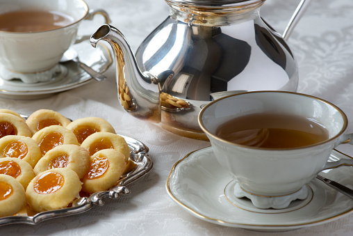 A perfect afternoon tea with silver teapot and biscuits