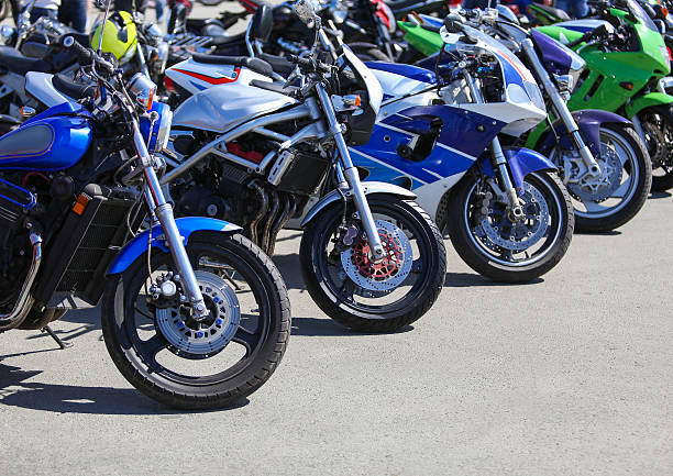multiple motorbikes lined up in a parking lot