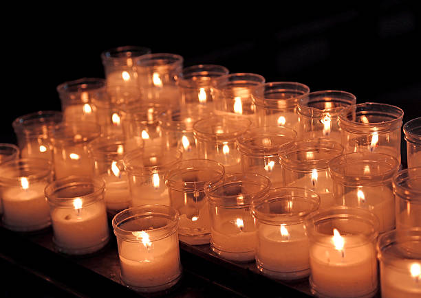 istock lit candles to pray inside a church 472362454