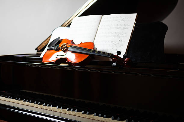 Classical music scene Classical music scene: violin and score on a piano chamber orchestra stock pictures, royalty-free photos & images