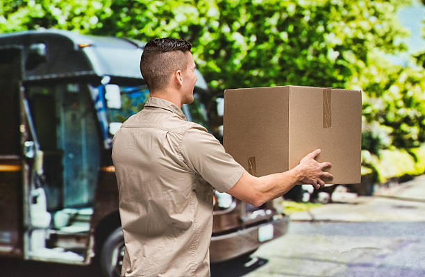 istock Man holding package outdoors 472364026