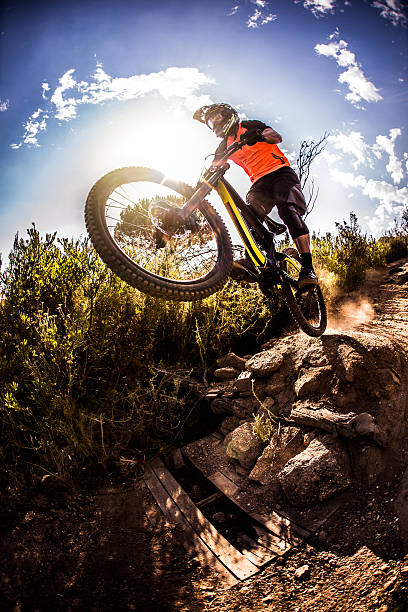 istock Mountain biker about to dirt jump over rough terrain 472366860