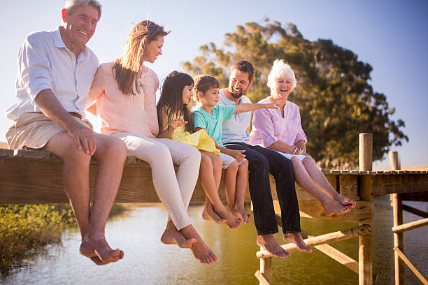 tres generaciones de una familia disfrutando juntos de vacaciones de verano - mother daughter grandmother jetty fotografías e imágenes de stock