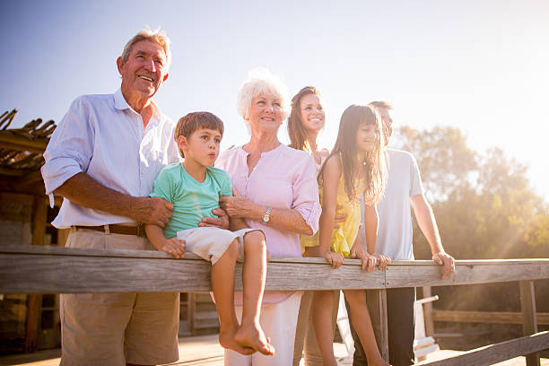 abuelos con su familia al aire libre con resplandor solar - mother daughter grandmother jetty fotografías e imágenes de stock