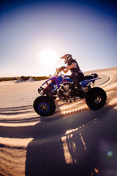 istock Professional quad biker racing over a sand dune 472367004