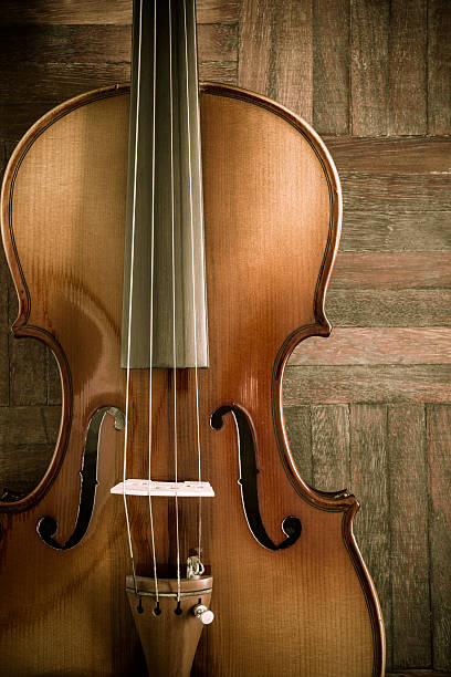 istock old vintage clasical violin on wood floor 472372244