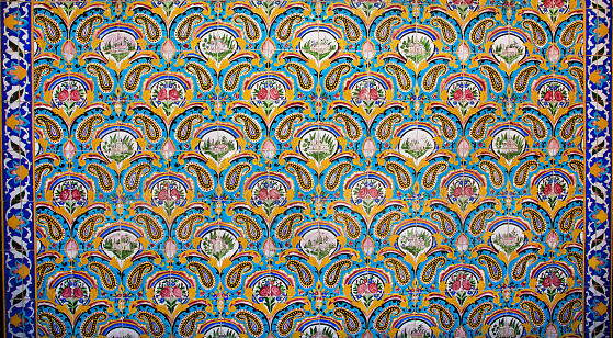 Meknes, Morocco-September 22, 2013: Close-up detail from the ceramic-patterned and stone-carved wall of the Moulay Ismail Tomb. Arabic inscriptions are carved into the stone.