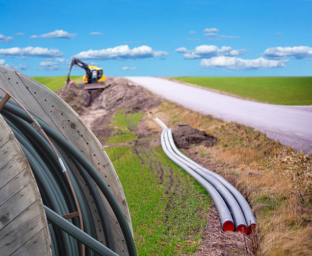 Digging for broadband Earth digger used to dig down cables for broadband connection in rural area bandwidth stock pictures, royalty-free photos & images