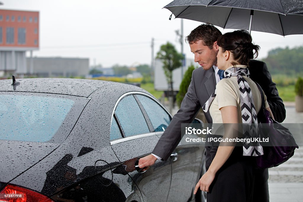 Young man opening door of car for woman 20-29 Years Stock Photo